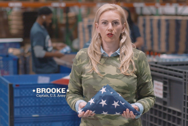 Veteran holds a folded American flag inside the Allegiance Flag Supply manufacturing facility
